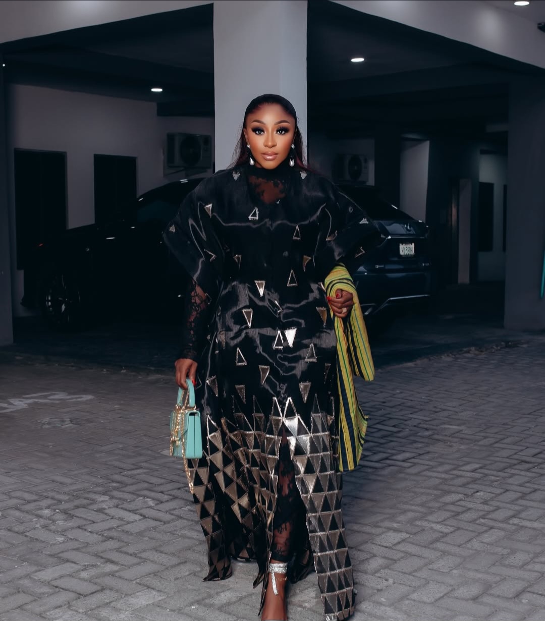 Ini Edo wearing a luxurious black and gold geometric-patterned Trish O Couture outfit