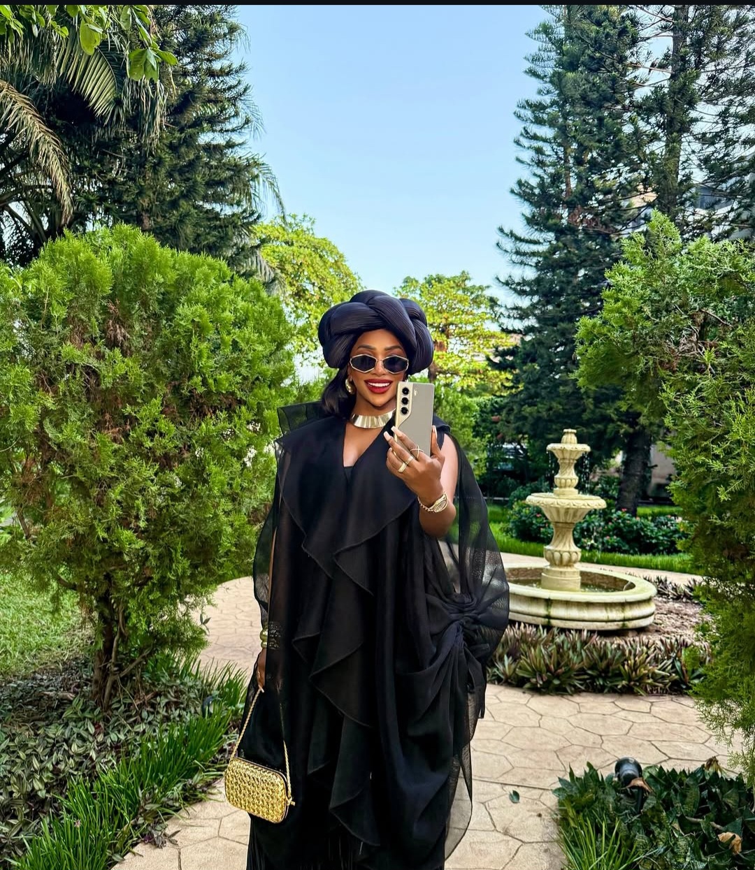 Chioma Good Hair posing in a layered black outfit with a black turban