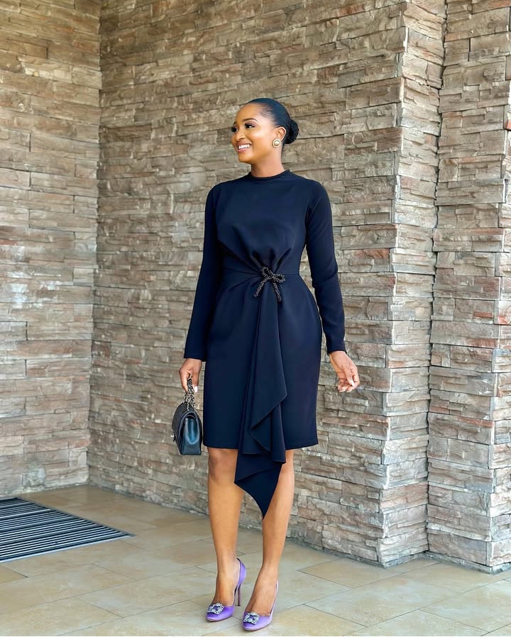 Powede Eniola in a black corporate midi dress
