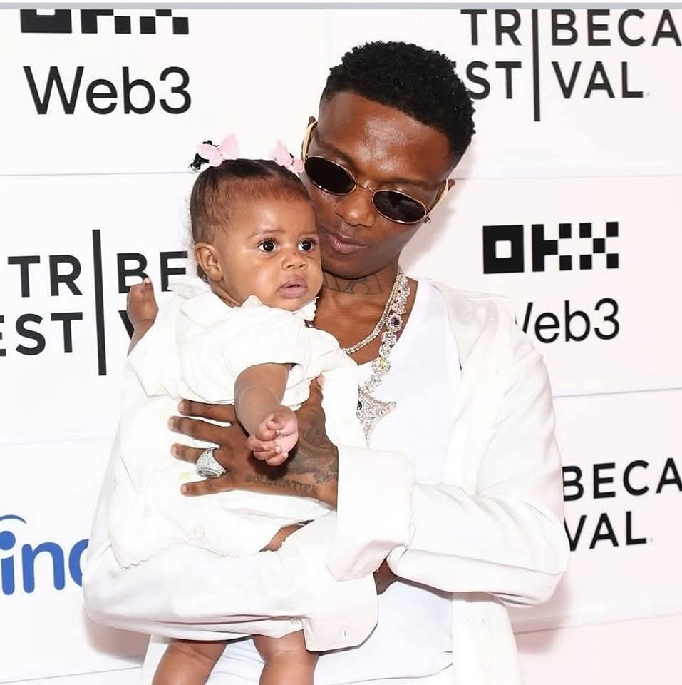 Wizkid smiles alongside partner Jada Pollock and their daughter on the red carpet