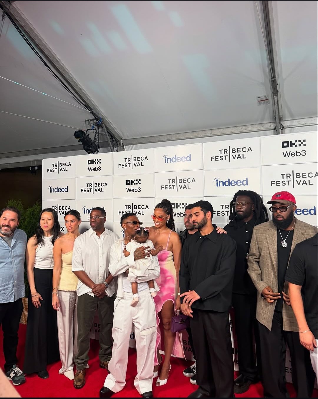 Wizkid smiles alongside partner Jada Pollock and their daughter on the red carpet
