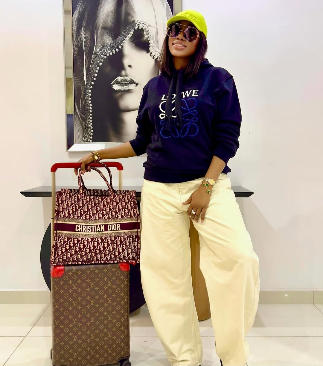Medlinboss wearing a neon green LOEWE cap, navy LOEWE hoodie