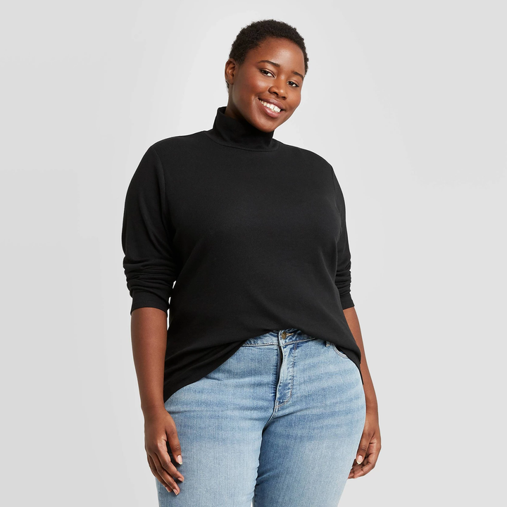 A black turtle neck paired with grey blue denim pants